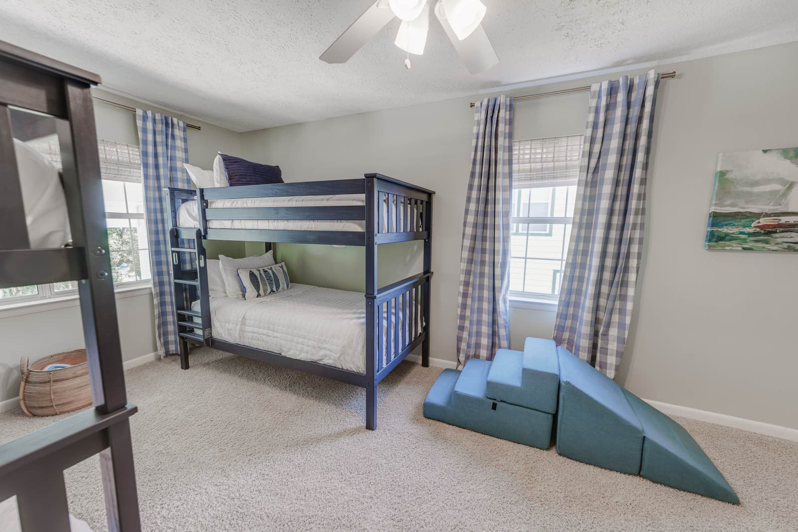 Bunk room bunk beds with gingham curtains and soft foam play steps