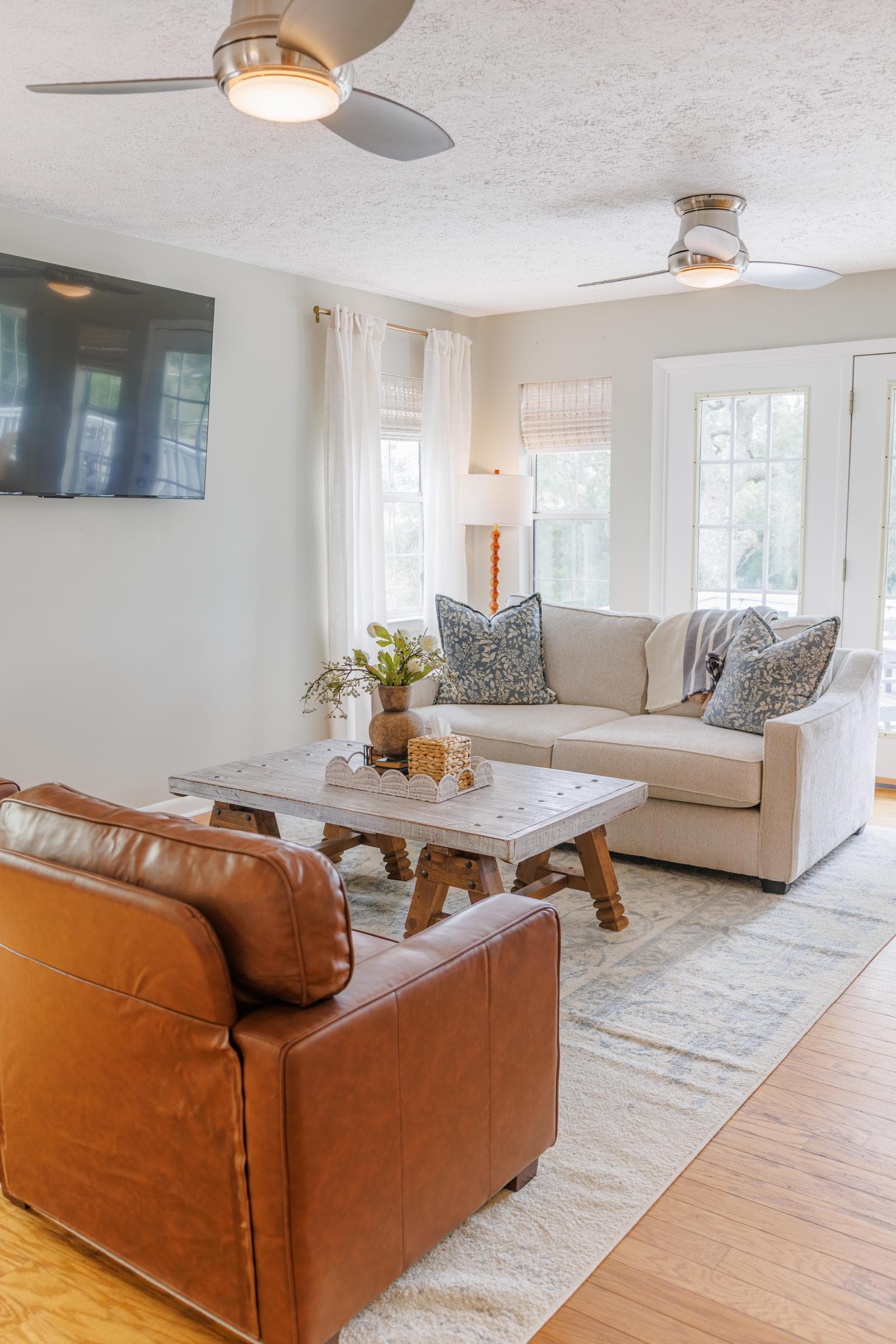 Second living room with a white sofa, leather chairs, and a wood coffee table