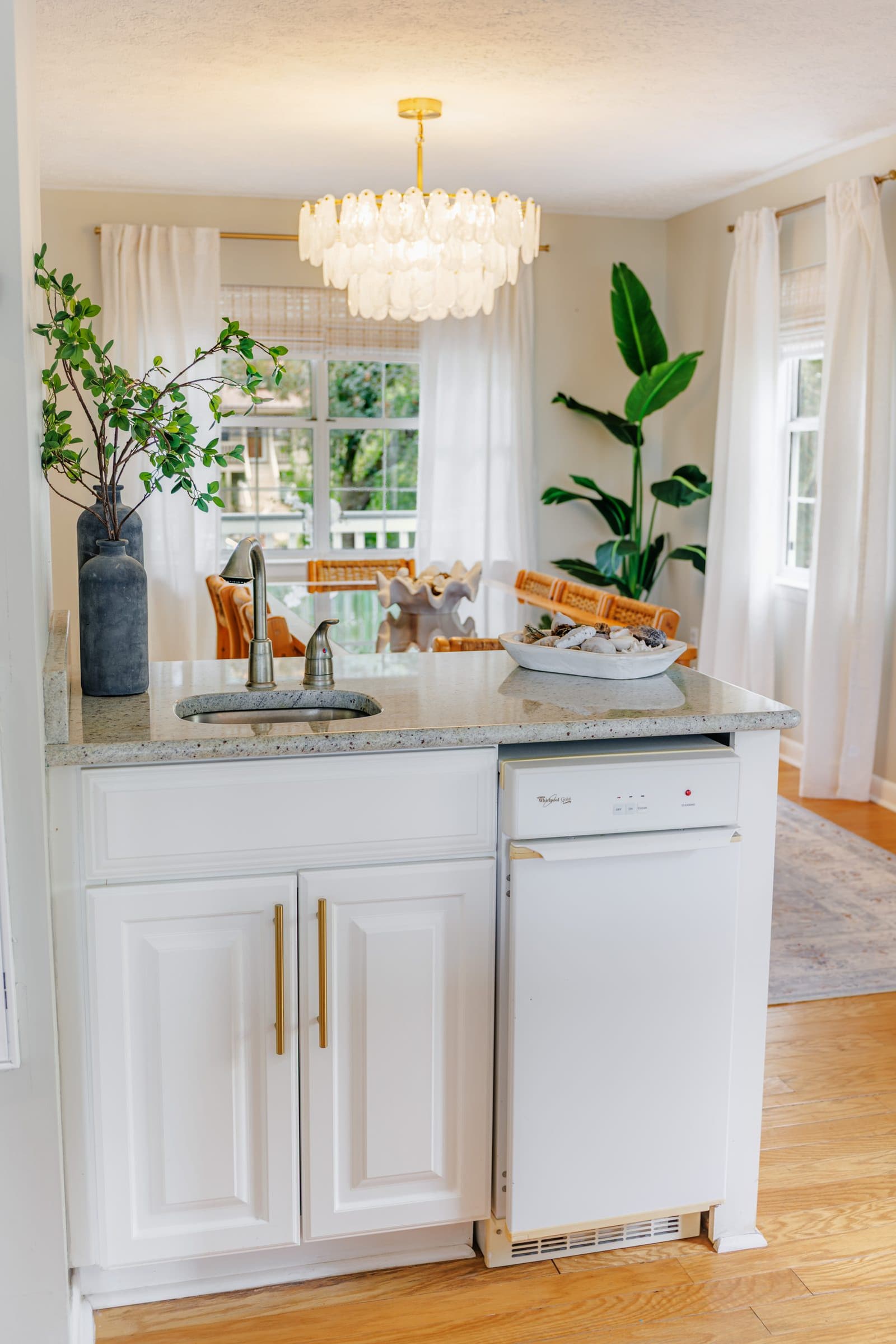 Kitchen counter with a sink and a small dishwasher, with the back porch doors beyond