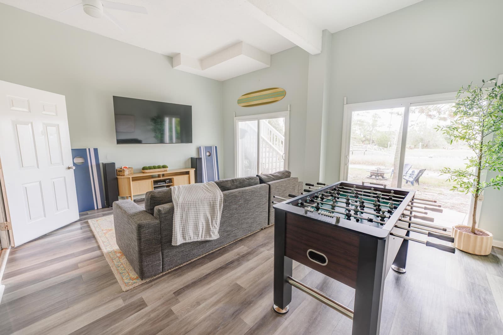 Game room with a foosball table, gray sectional, and TV