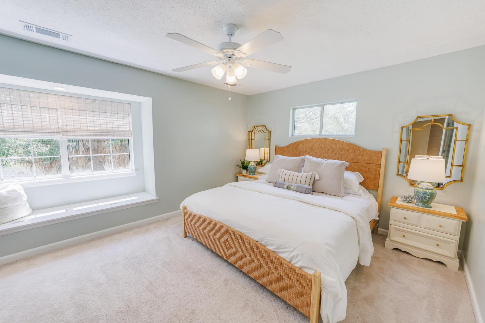 Classic guest bedroom with a woven-headboard king bed and ceiling fan
