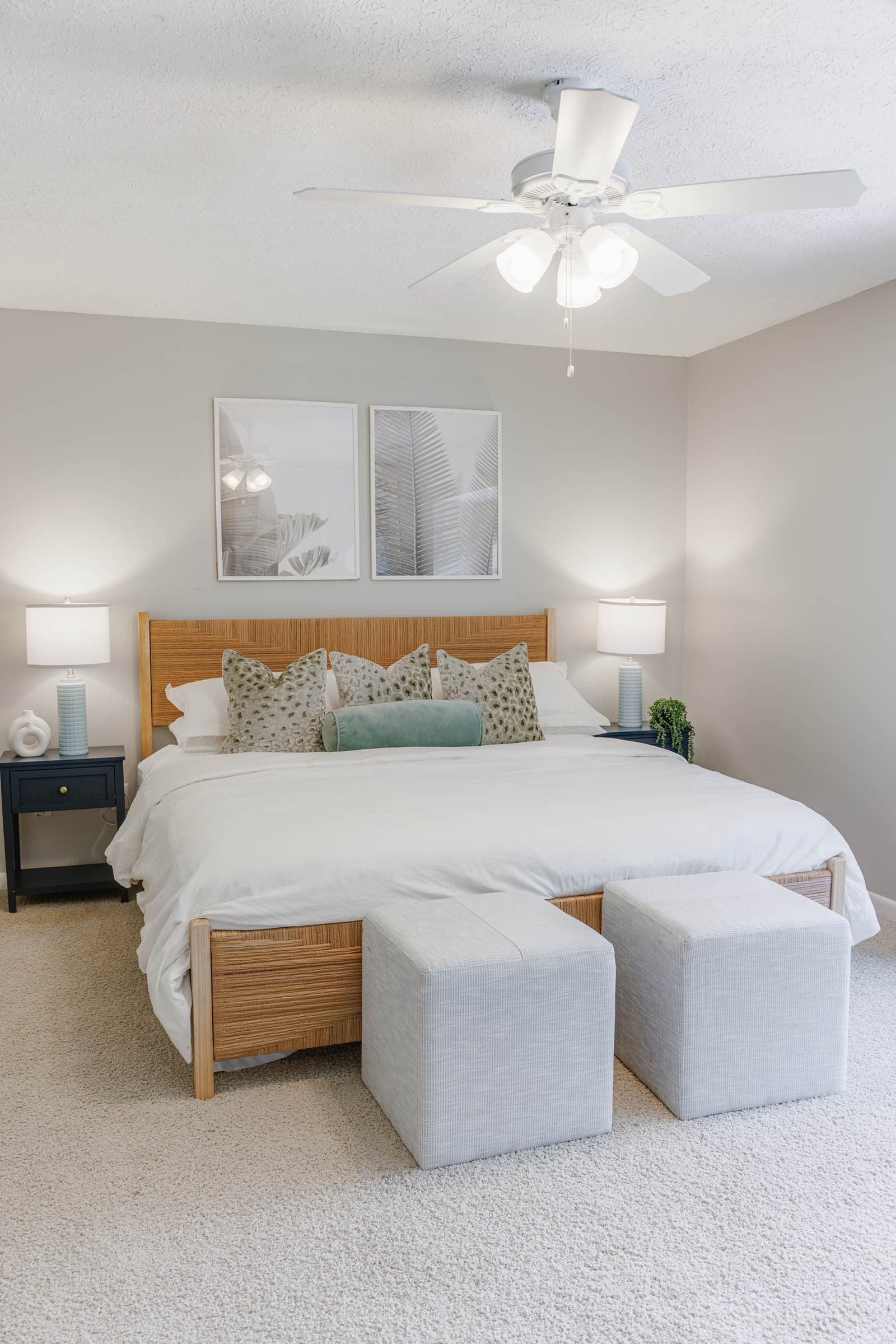 Playful guest bedroom king bed with teal pillows and navy nightstands