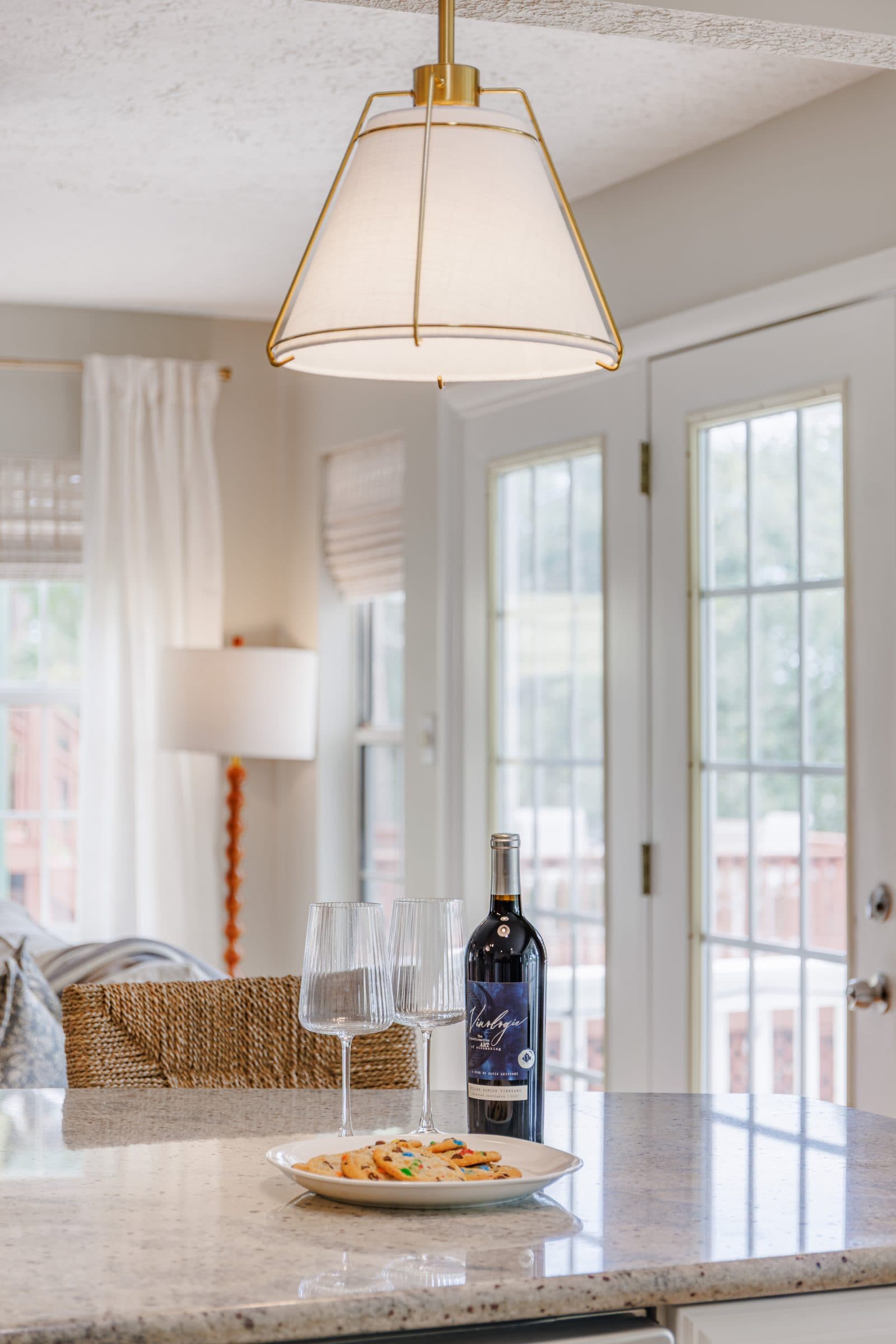 Breakfast corner with French doors, a floor lamp, and a bottle of wine with glasses