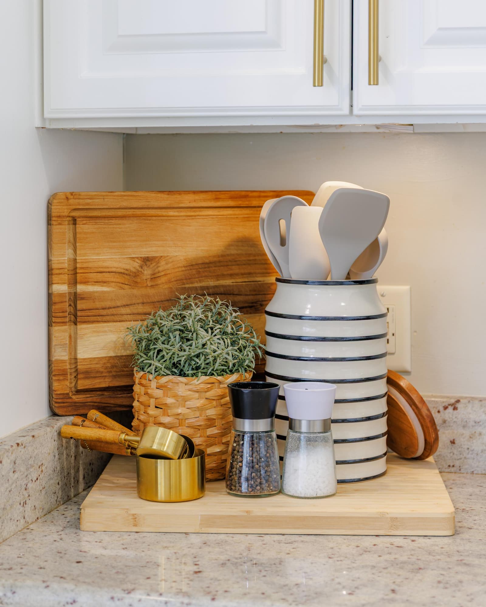 Kitchen counter with a wooden cutting board, utensil crock, and pepper mill