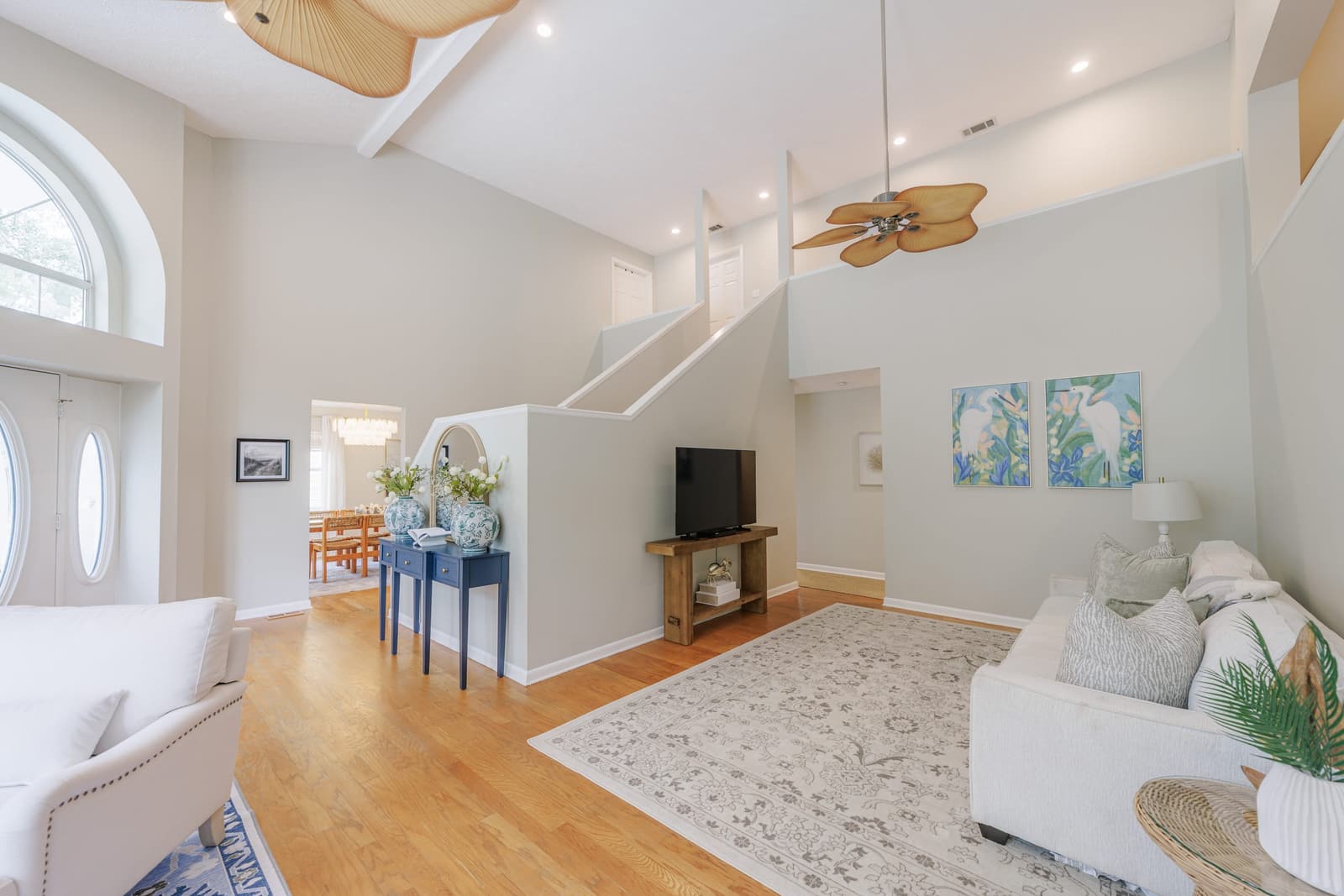 Living room looking toward the staircase, with a white sofa and blue console table