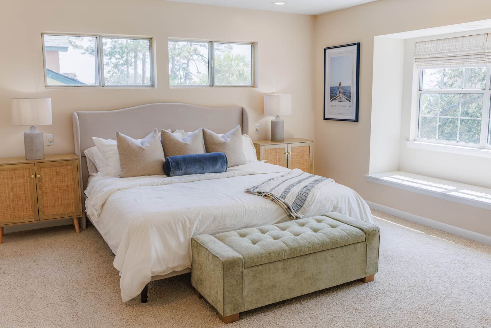 Primary suite king bed with a green upholstered bench at the foot
